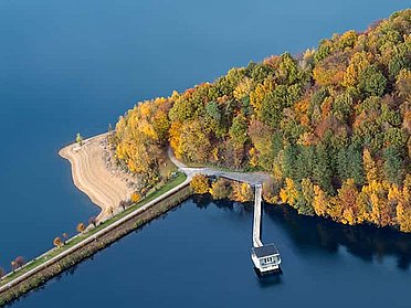 Ausschnitt der Dhünntalsperre mit See, Ufer, Wald, Damm und Häuschen auf dem Seh.