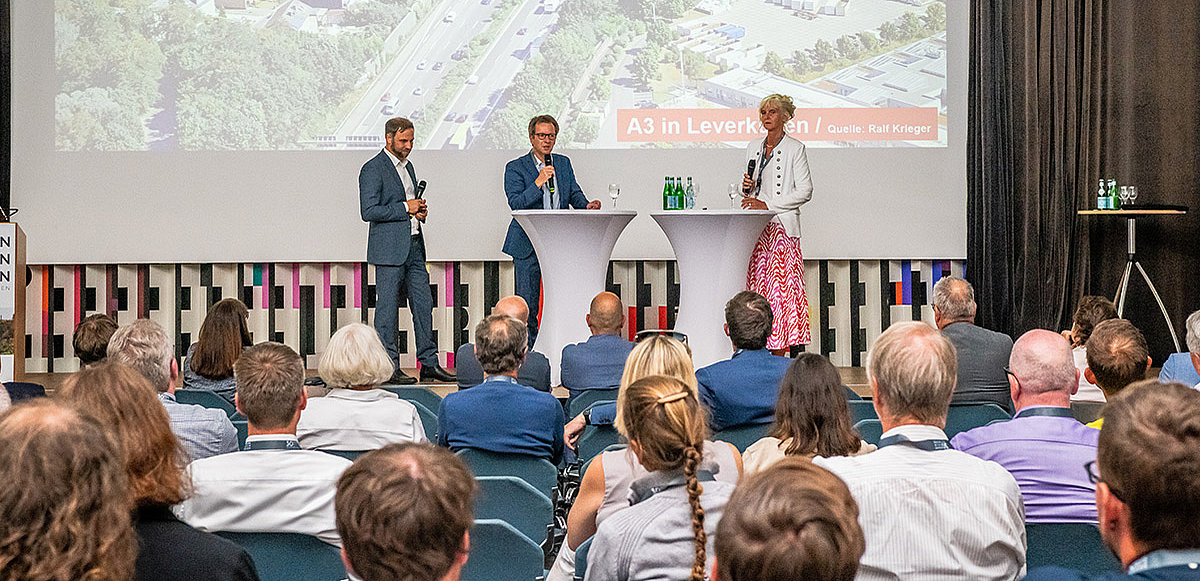 Podiumsrunde im Fachforum A "Transformation und Raum" mit drei Teilnehmenden und Zuhörer*innen im Vordergrund