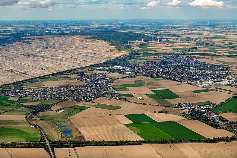 Luftaufnahme des Tagebau Hambach. Außerdem die stadt Elsdor, Agrarflächen und Windräder.